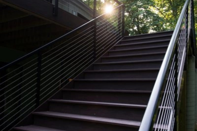 Modern Stairs with Conduit Railing from Large Porch to Backyard Outdoor Living Area | Denny + Gardner Outdoor Living Space Services